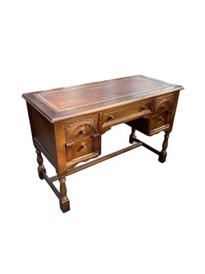 Lot 2110 - A modern Priory style oak kneehole desk, with...