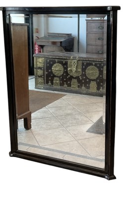 Lot 74 - A modern ebonised bevelled glass wall mirror,...