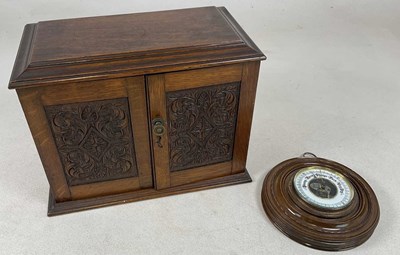 Lot 717 - An oak smoker's cabinet with carved doors,...