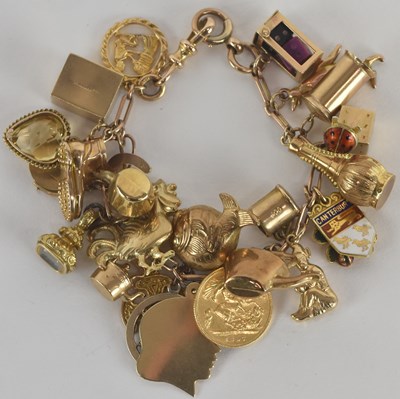 Lot 1569 - A 9ct gold charm bracelet, with twenty-seven...