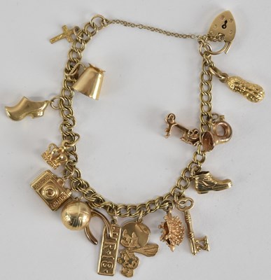 Lot 1585 - A 9ct gold charm bracelet, with fourteen gold...