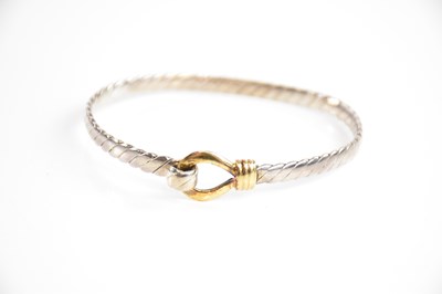 Lot 210 - An 18ct yellow gold and silver bangle, with...