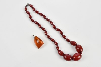 Lot 9 - A graduated cherry amber coloured necklace and...