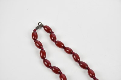 Lot 9 - A graduated cherry amber coloured necklace and...