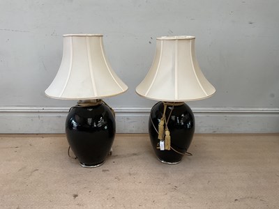 Lot 2406 - A pair of decorative black glazed table lamps...