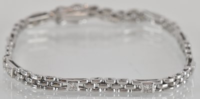 Lot 1575 - An 18ct white gold line bracelet, with nine...