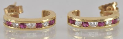 Lot 1501 - A pair of gold diamond and ruby channel set...