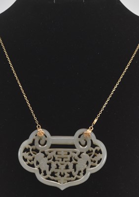 Lot 585 - A Chinese pierced jade plaque, suspended on a...