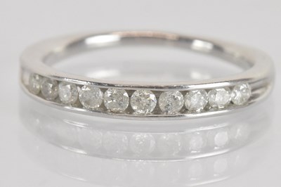 Lot 1285 - A 9ct white gold diamond set half eternity...