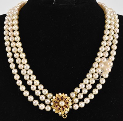 Lot 1410 - A cultured pearl three strand necklace, with...