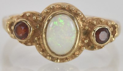 Lot 1363 - A 9ct gold oval white opal bezel set ring,...