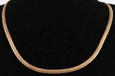 Lot 1437 - A 9ct gold semi-rigid necklace, with lobster...