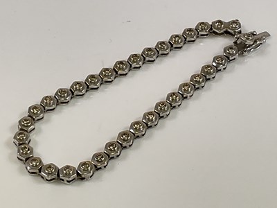 Lot 525 - An 18ct white gold and diamond line bracelet,...