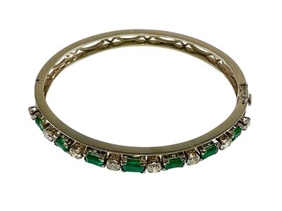Lot 451 - A 14ct white gold diamond and emerald hinged...