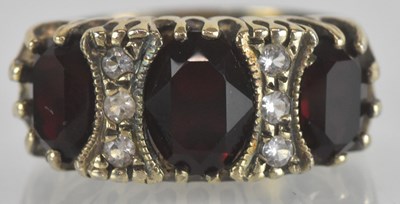 Lot 1290 - A 9ct yellow gold red and white three stone...
