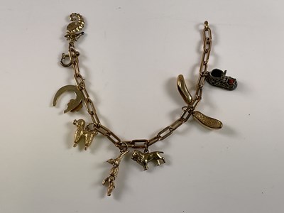 Lot 546 - A yellow metal charm bracelet set with a...
