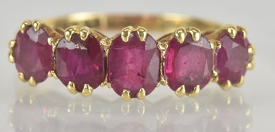 Lot 1243 - An 18ct yellow gold ruby five stone ring, the...