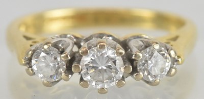 Lot 1268 - An 18ct yellow gold diamond three stone ring,...