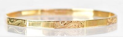 Lot 809 - A 9ct yellow gold faceted bangle, with...