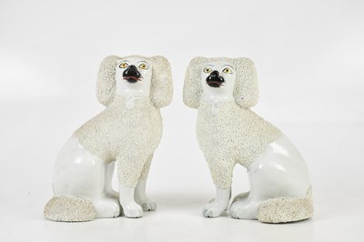 Lot 143 - STAFFORDSHIRE; a pair of poodles, height 24cm...