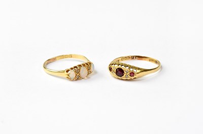 Lot 1029 - Two 18ct gold rings, one set with three...