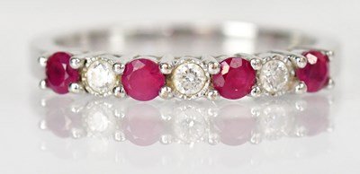 Lot 766 - An 18ct white gold ring set with four rubies...