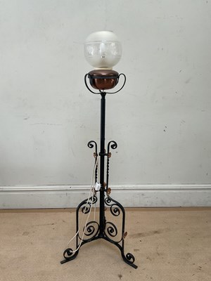 Lot 2409 - A wrought iron standard lamp, with copper...