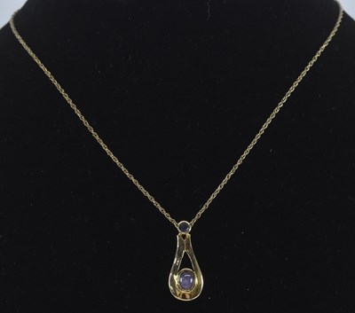 Lot 1243 - A 9ct yellow gold cabochon amethyst and...