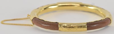 Lot 1309 - A yellow metal mounted hardstone snap bangle,...