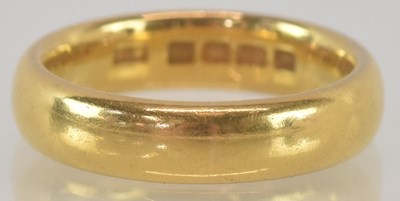 Lot 1155 - A 22ct yellow gold wedding band, size K,...