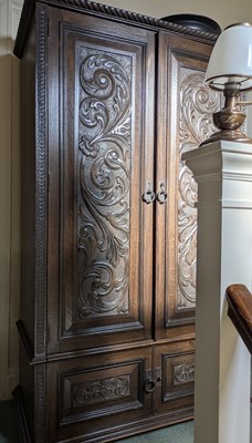 Lot 57 - An early 20th century carved oak two-door robe,...