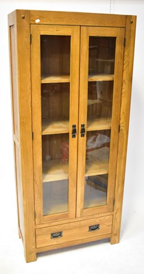 Lot 60 - An oak glazed bookcase with a pair of doors...