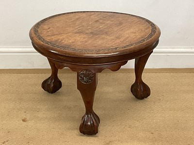 Lot 556 - A walnut circular side table with carved band...