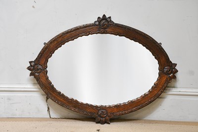 Lot 2298 - A carved oak oval wall mirror.