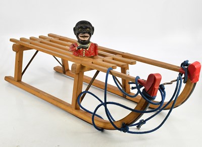 Lot 1330 - A vintage wooden sledge and a cast metal Jolly...