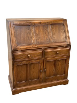 Lot 2318 - ERCOL; an oak bureau, with fall above two...