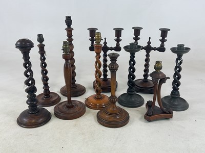 Lot 1047 - A collection of turned oak candlesticks,...