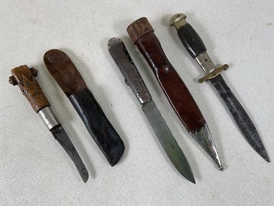 Lot 114 - A unusual knife in leather scabbard, the grip...