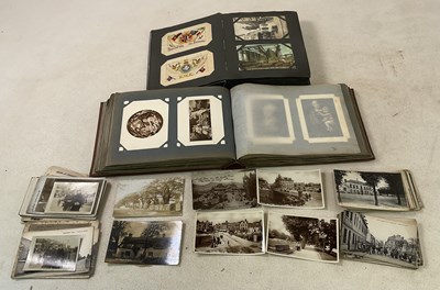 Lot 126 - Two albums of postcards, the first album...