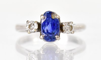 Lot 1039 - A white metal ring set with a sapphire flanked...