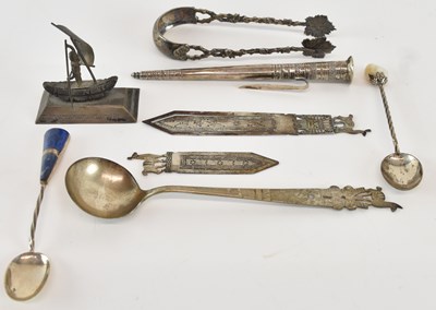 Lot 1093 - A small Eastern white metal model of a figure...