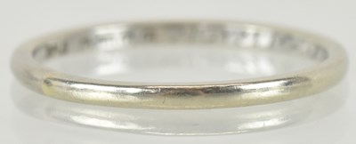 Lot 1209 - An 18ct white gold thin band ring, with...