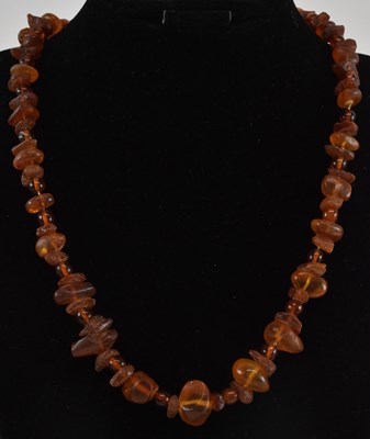 Lot 1251 - A rough cut amber bead single strand necklace,...