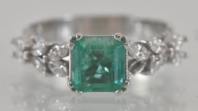 Lot 1145 - An 18ct white gold emerald and diamond set...