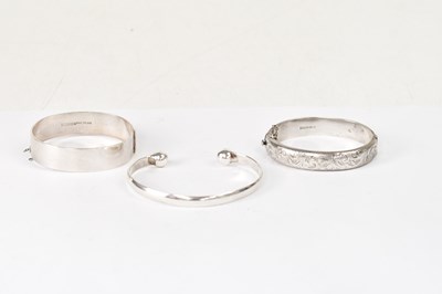 Lot 1052 - Three hallmarked silver bangles, comprising a...