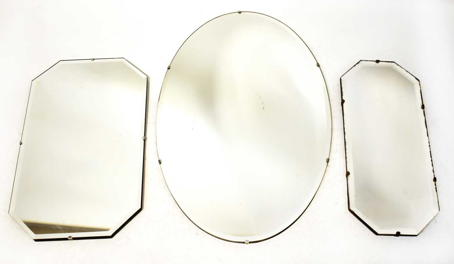 Lot 132 - Three frameless bevelled edge mirrors, the...