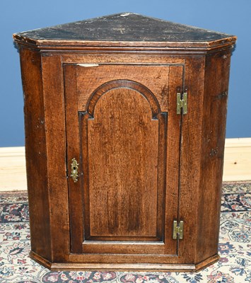 Lot 2999 - A Georgian oak hanging corner cupboard, with...
