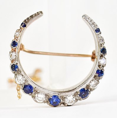 Lot 1057 - A 9ct yellow gold crescent-shaped brooch set...