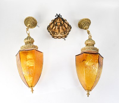 Lot 143 - A pair of amber glass ceiling pendant lights,...