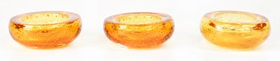 Lot 569 - Three amber-coloured glass ashtrays with...